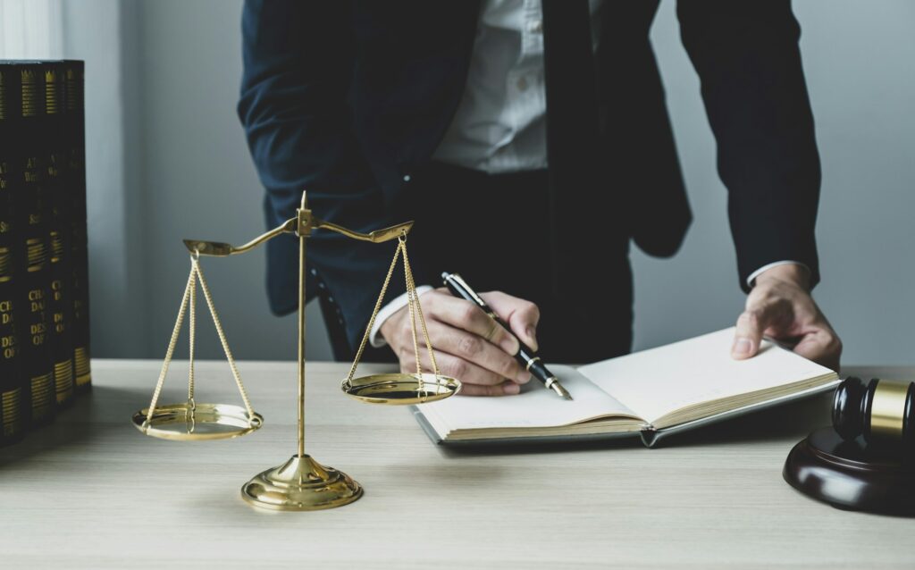 Lawyer hand holding pen and providing legal consult business dispute service at the office